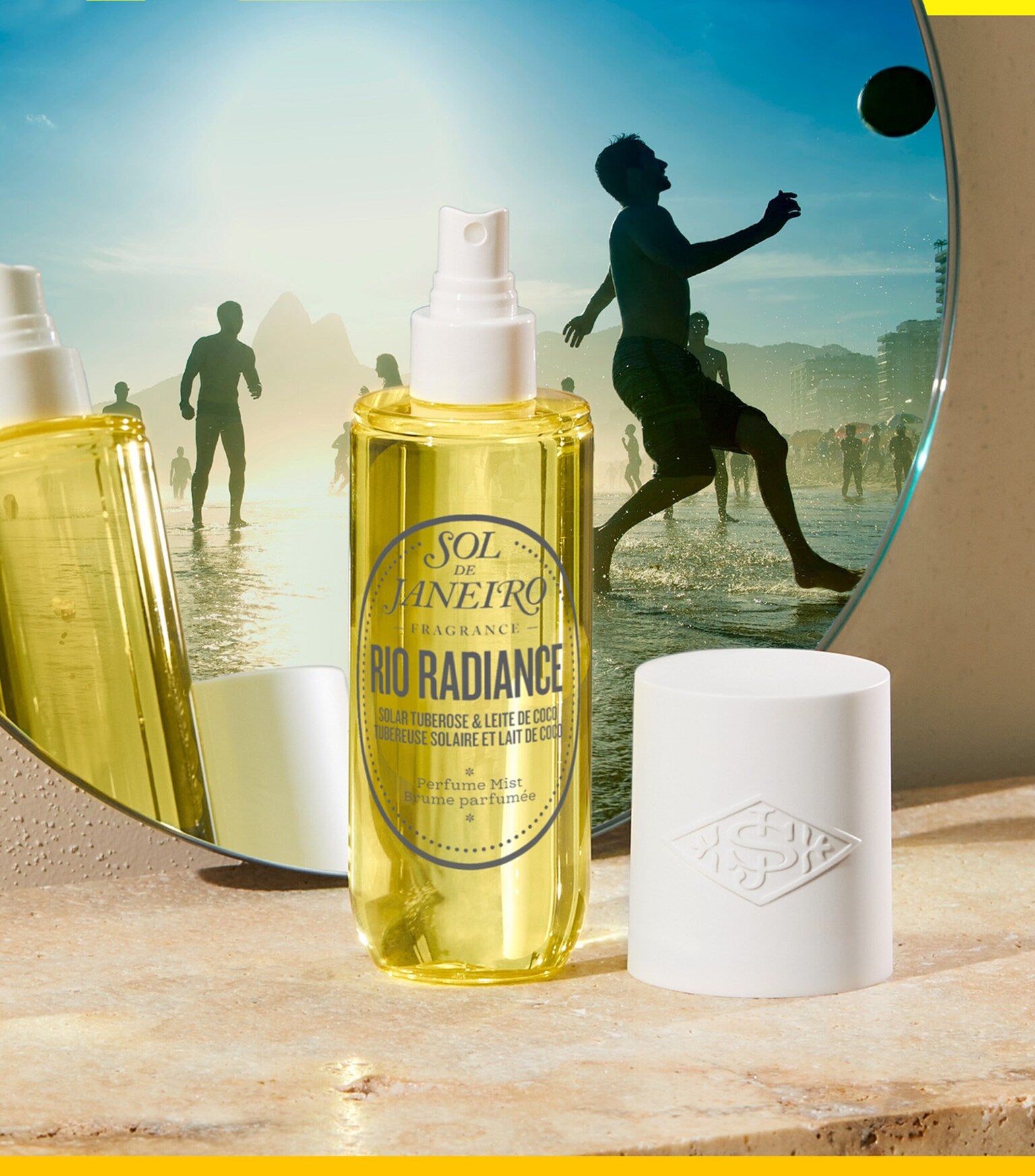 Bottle of Sol de Janeiro Rio Radiance fragrance with a beach scene in the background